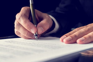 En advokat fra Brandt-Madsen advokatfirma skriver under på en aftale. En advokat fra Brandt-Madsen advokatfirma skriver under på en aftale.